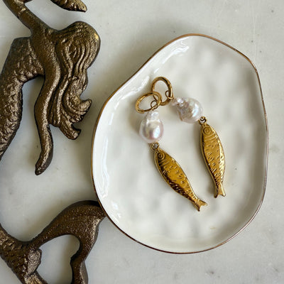 The Sardinia Earrings by Wild Alabaster — gold-plated brass earrings with baroque pearls and sculpted fish charms, coastal-inspired statement jewelry.