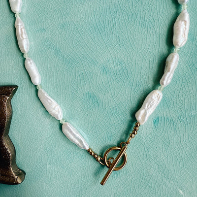 The Winnie Necklace with faceted peridot beads and a single freshwater pearl